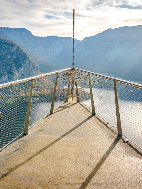 Skywalk lookout bridge overlooking Hallstatt, Austria with mountain and lake views.