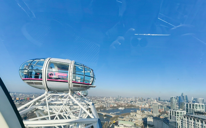 London Eye capsule with city skyline view, River Thames visible below.