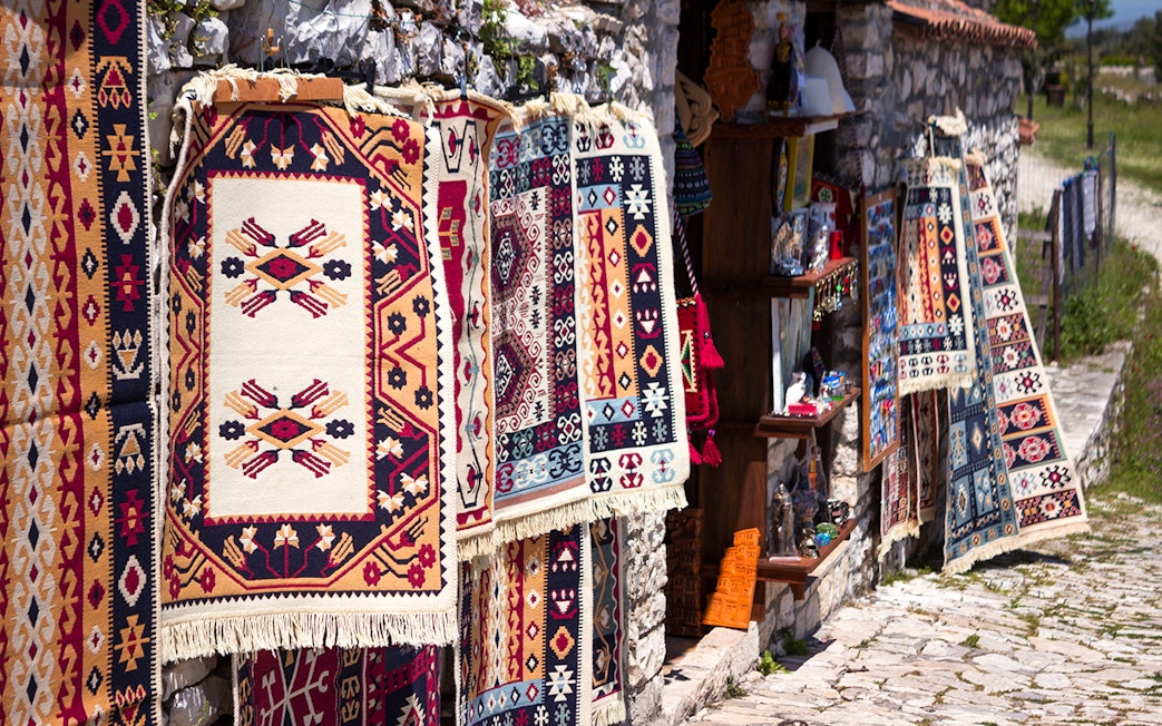 Traditional Albanian carpets displayed for sale near Berat fortress.