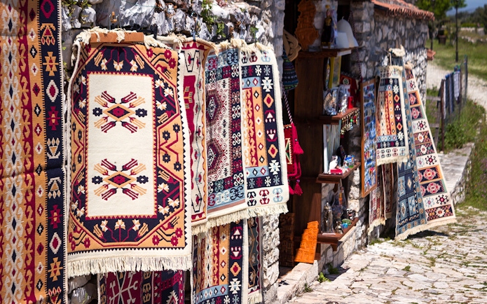 Traditional Albanian carpets displayed for sale near Berat fortress.