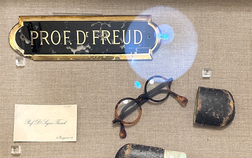 Sigmund Freud's nameplate, glasses, and personal items at Sigmund Freud Museum.