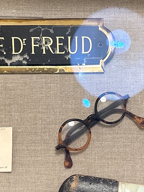 Sigmund Freud's nameplate, glasses, and personal items at Sigmund Freud Museum.