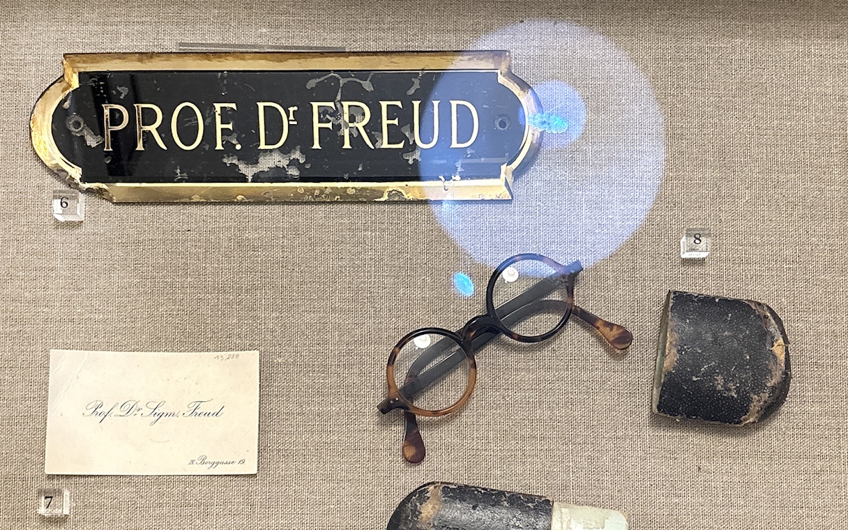 Sigmund Freud's nameplate, glasses, and personal items at Sigmund Freud Museum.