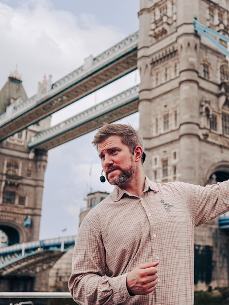 Guide explaining Tower Bridge to guests on the Tower of London Cruise boat.