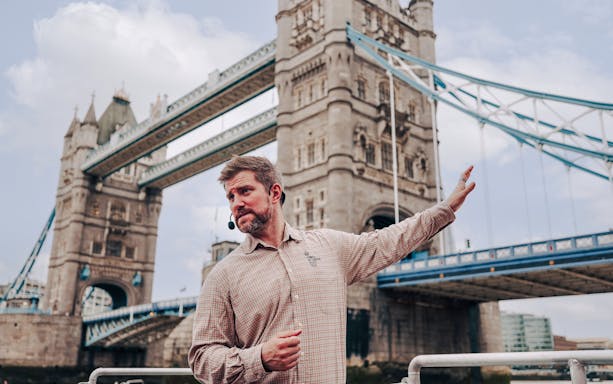 Guide explaining Tower Bridge to guests on the Tower of London Cruise boat.