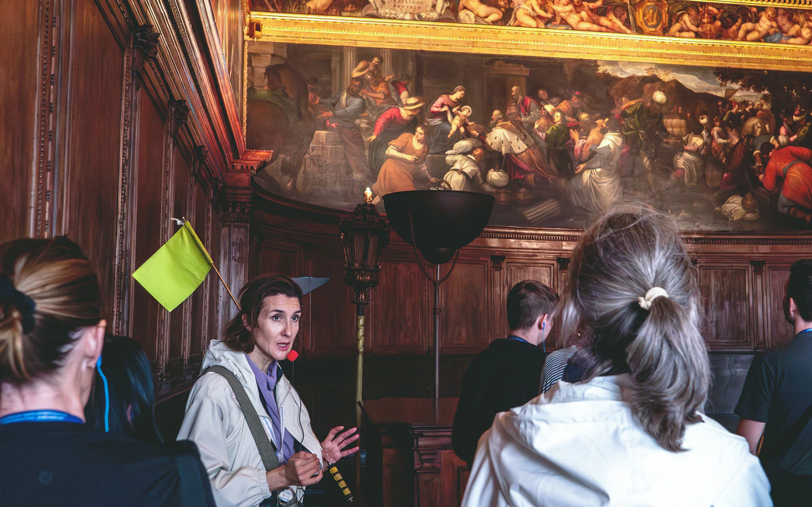 Tour guide explaining artwork to visitors inside Doge's Palace, Venice.