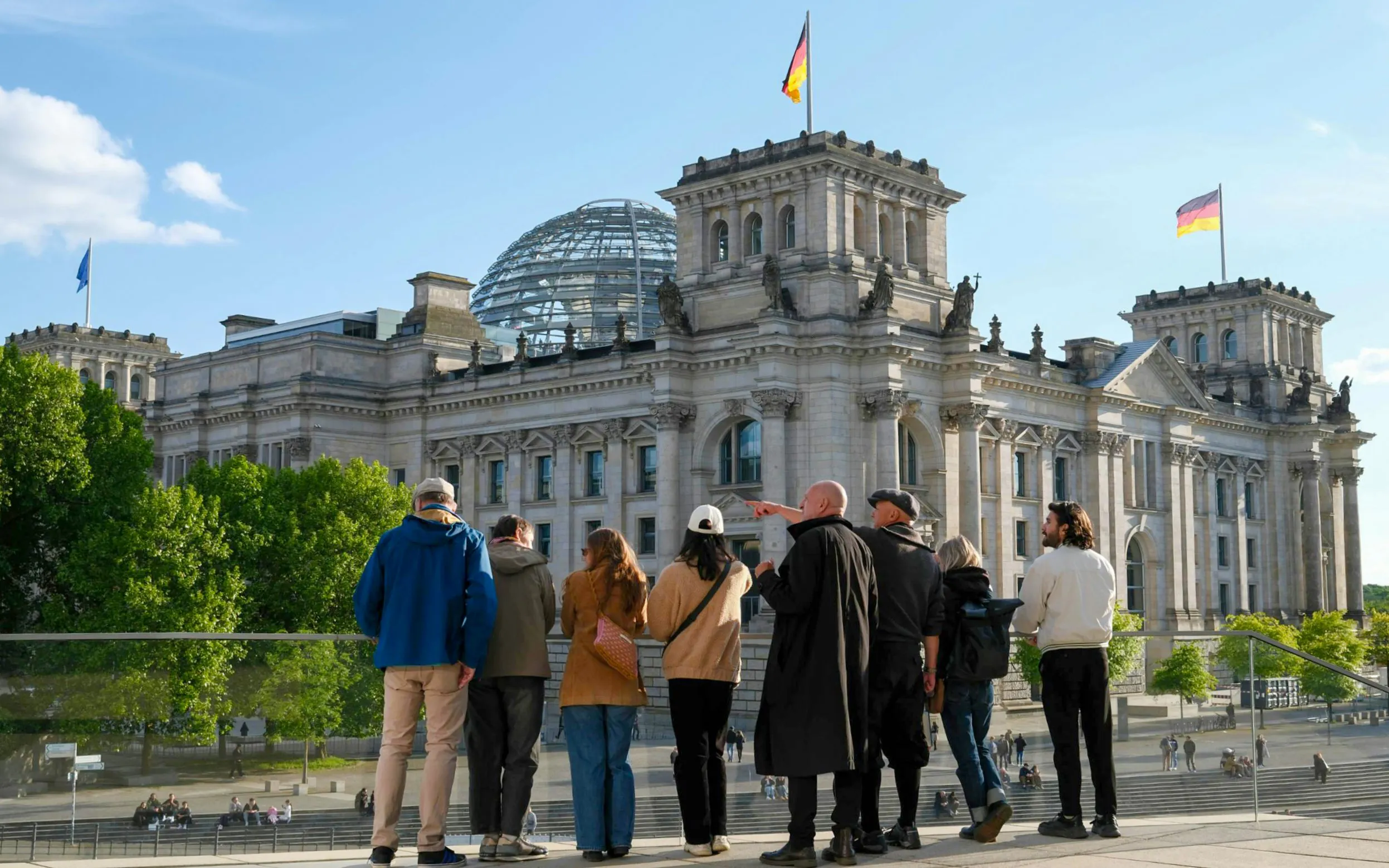 Guided group viewing the Reichstag building and dome in Berlin's Government District.