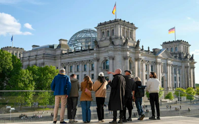 Guided group viewing the Reichstag building and dome in Berlin's Government District.