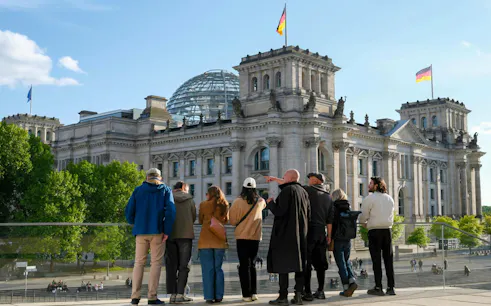 Guided group viewing the Reichstag building and dome in Berlin's Government District.
