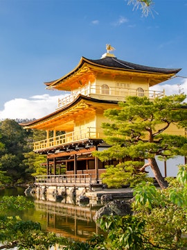 Golden Pavilion at Kinkaku-ji Temple, Kyoto, surrounded by trees and reflecting in a pond.