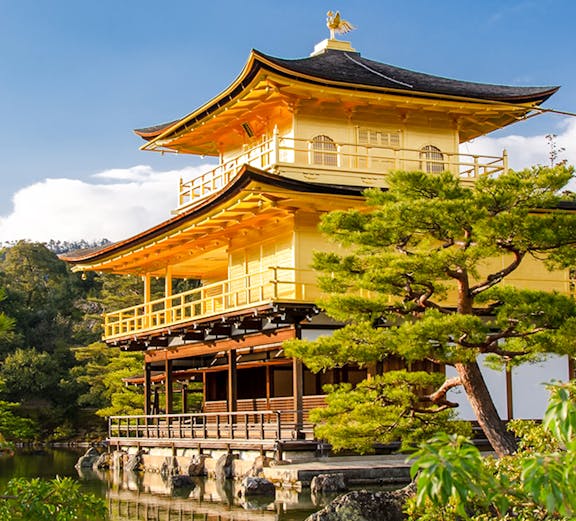 Golden Pavilion at Kinkaku-ji Temple, Kyoto, surrounded by trees and reflecting in a pond.