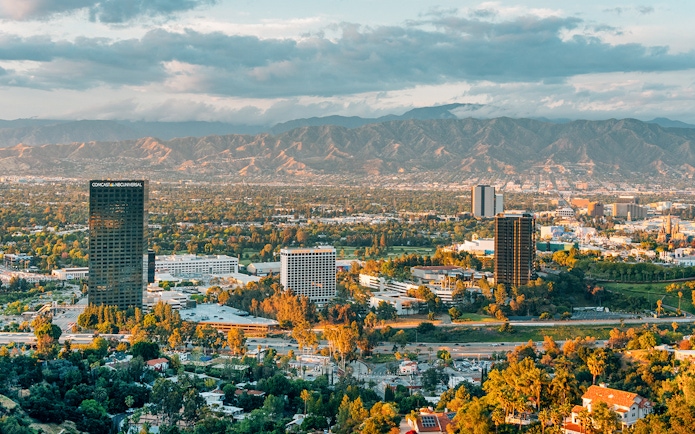 Skyline view of Los Angeles with mountains, highlighting celebrity homes tour area.