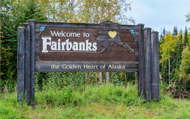 Welcome to Fairbanks, Alaska sign on a forested highway.