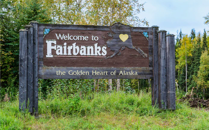 Welcome to Fairbanks, Alaska sign on a forested highway.