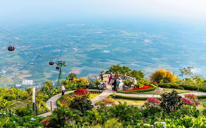 Cable cars over lush gardens at Sun World Ba Den Mountain, Vietnam.