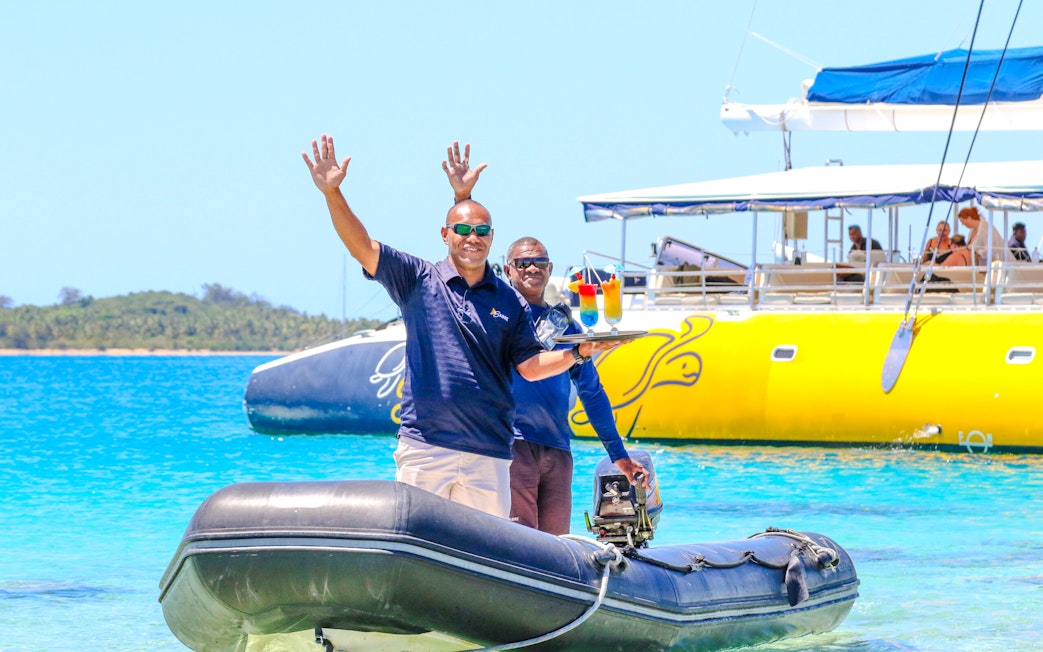 Staff delivering drinks on a speedboat, South Sea Sailing, Fiji.