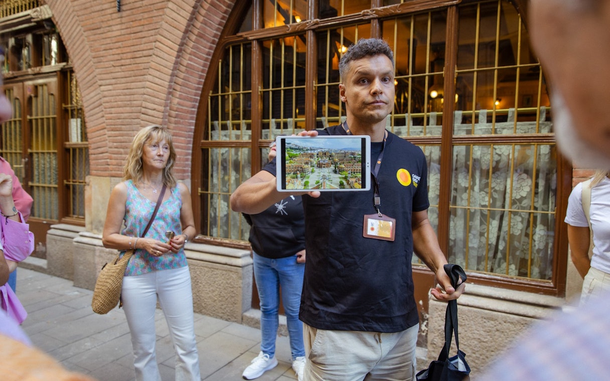 Tour guide showing a tablet to tourists on a walking tour in Barcelona.