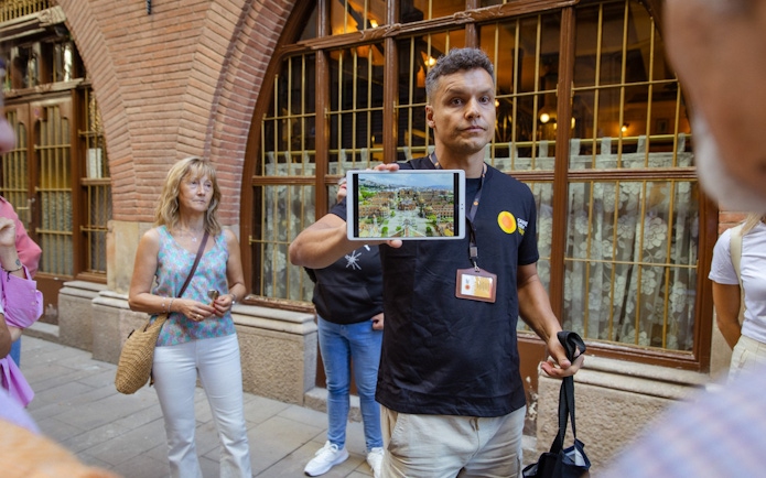 Tour guide showing a tablet to tourists on a walking tour in Barcelona.