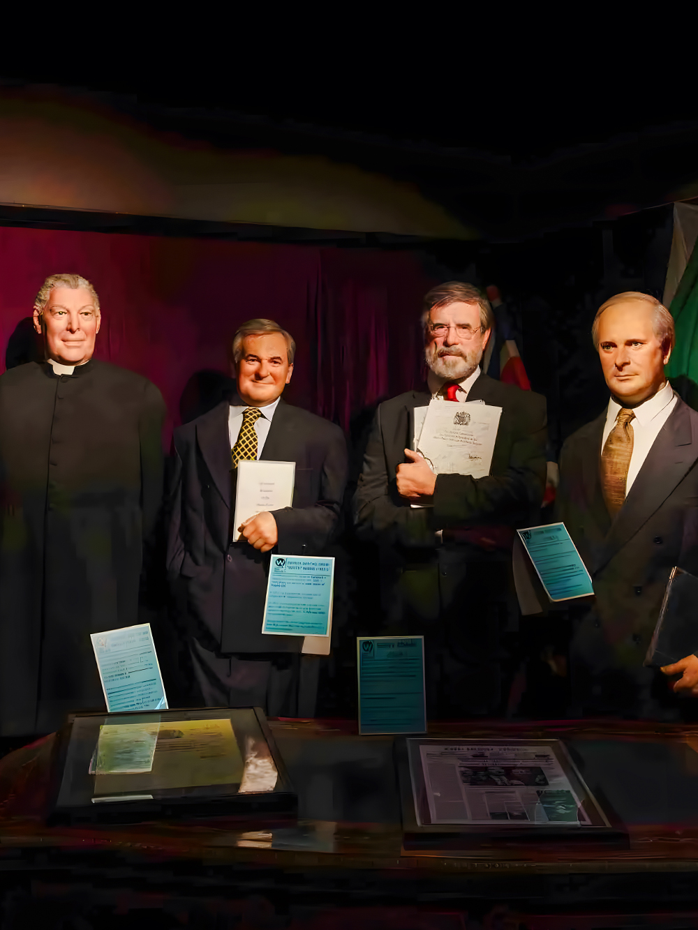 Wax figures of historical figures holding documents at Wax Museum Dublin.