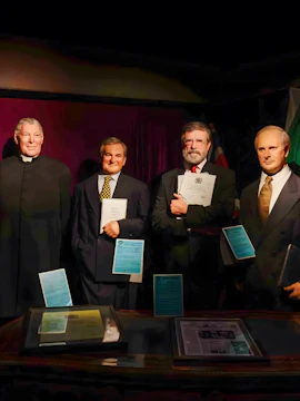 Wax figures of historical figures holding documents at Wax Museum Dublin.