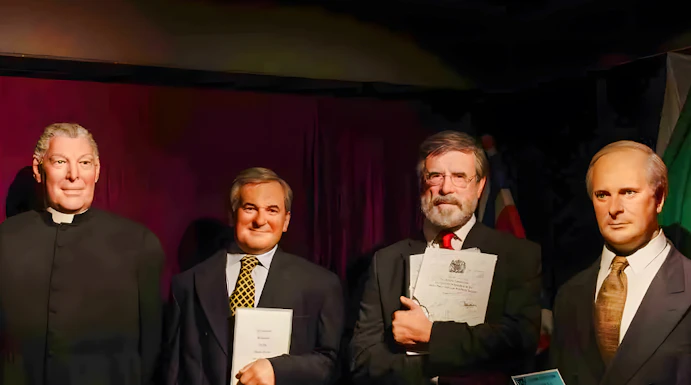Wax figures of historical figures holding documents at Wax Museum Dublin.