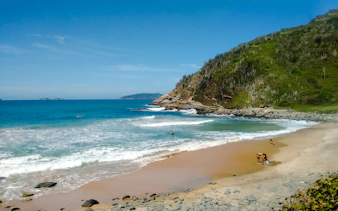 Beach at Emerências and José Gonçalves, Rio de Janeiro, with waves and rocky shoreline.