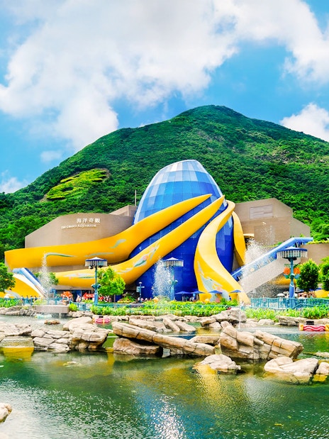 The Grand Aquarium at Ocean Park, Hong Kong with vibrant architecture and surrounding greenery.