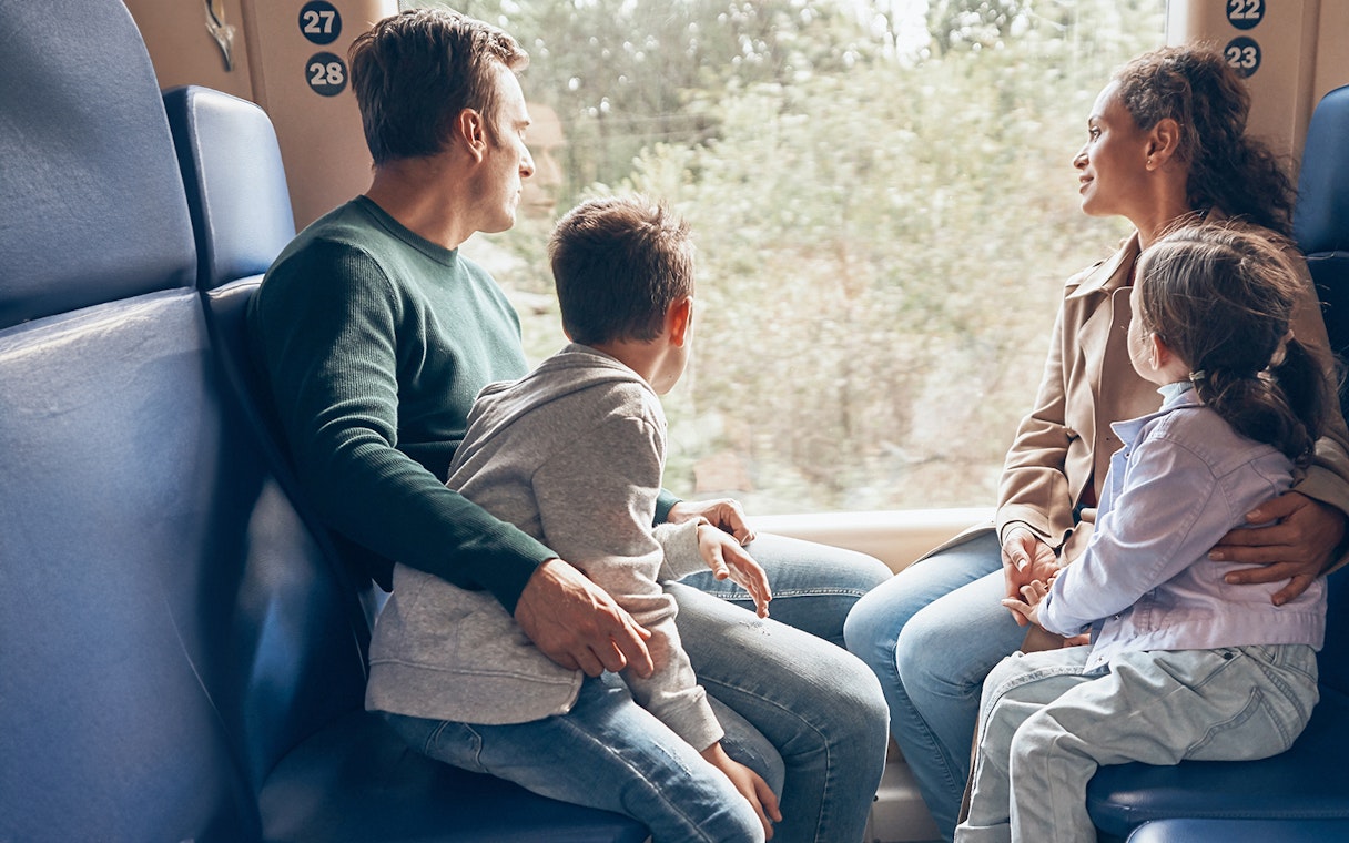 Family enjoying scenic train ride through countryside.