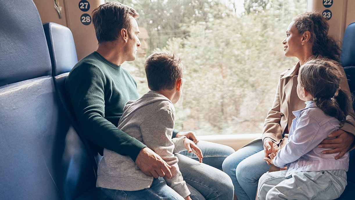 Family enjoying scenic train ride through countryside.