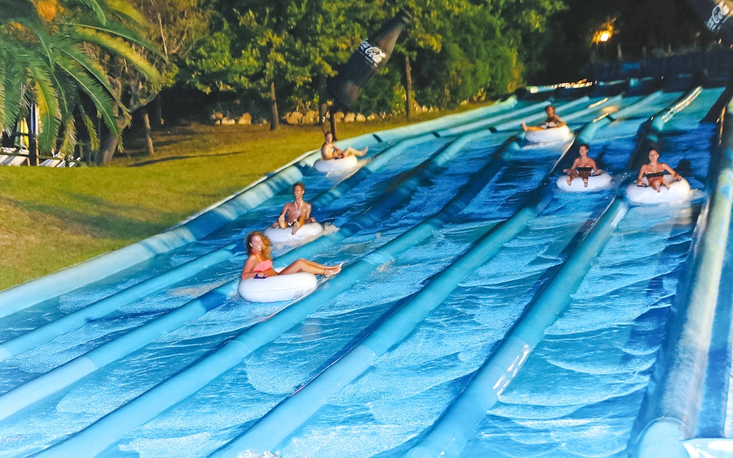 Visitors enjoying water slides at Aquafan Water Park, Italy.
