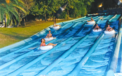 Visitors enjoying water slides at Aquafan Water Park, Italy.