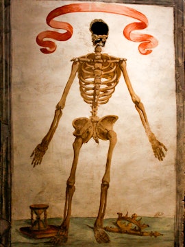 Skeleton mural with hourglass and crown in Catacombs of San Gaudioso, Naples.
