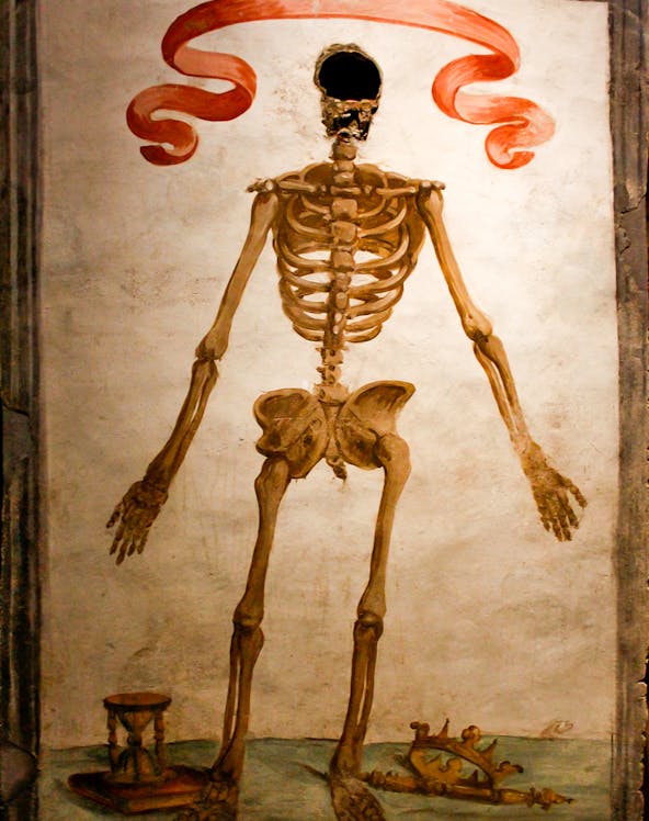 Skeleton mural with hourglass and crown in Catacombs of San Gaudioso, Naples.