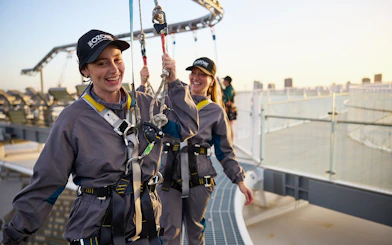 People enjoying a rooftop harness walk at sunset during the Vertigo by Twilight tour.