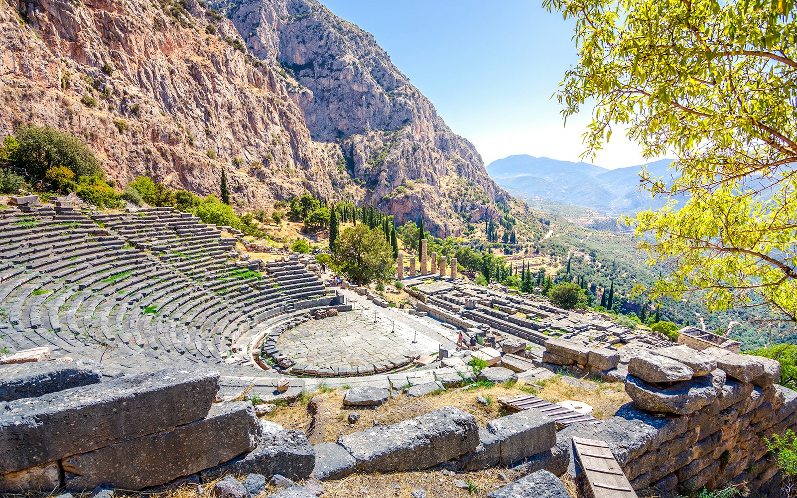 Ancient Theater of Delphi with stone seating and mountain backdrop in Greece.