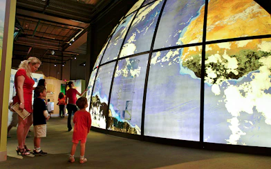 Visitors exploring large illuminated globe at Franklin Institute.