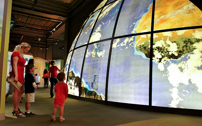 Visitors exploring large illuminated globe at Franklin Institute.