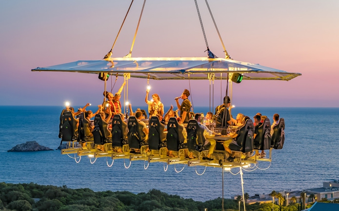 Guests dining at suspended table with ocean view in Dubrovnik.