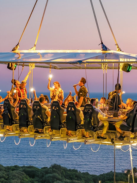 Guests dining at suspended table with ocean view in Dubrovnik.