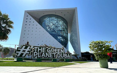 Green Planet Dubai exterior with lush greenery and unique architecture.