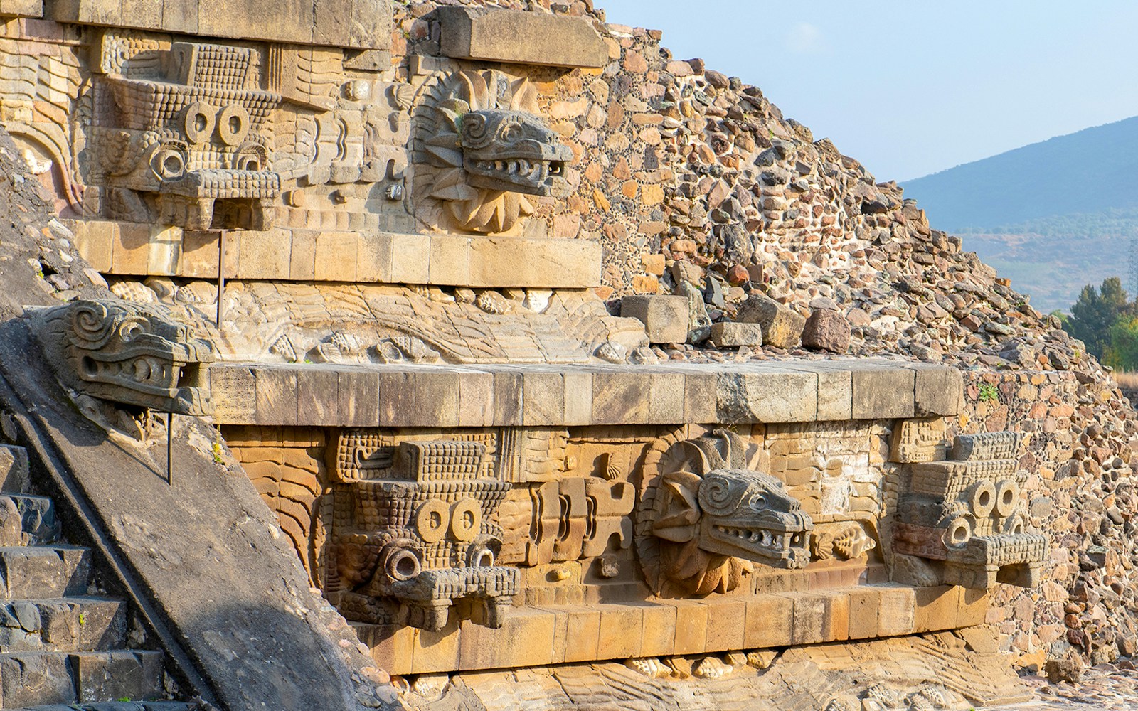 Temple of Quetzalcoatl with intricate carved stone serpent heads in Teotihuacan, Mexico.