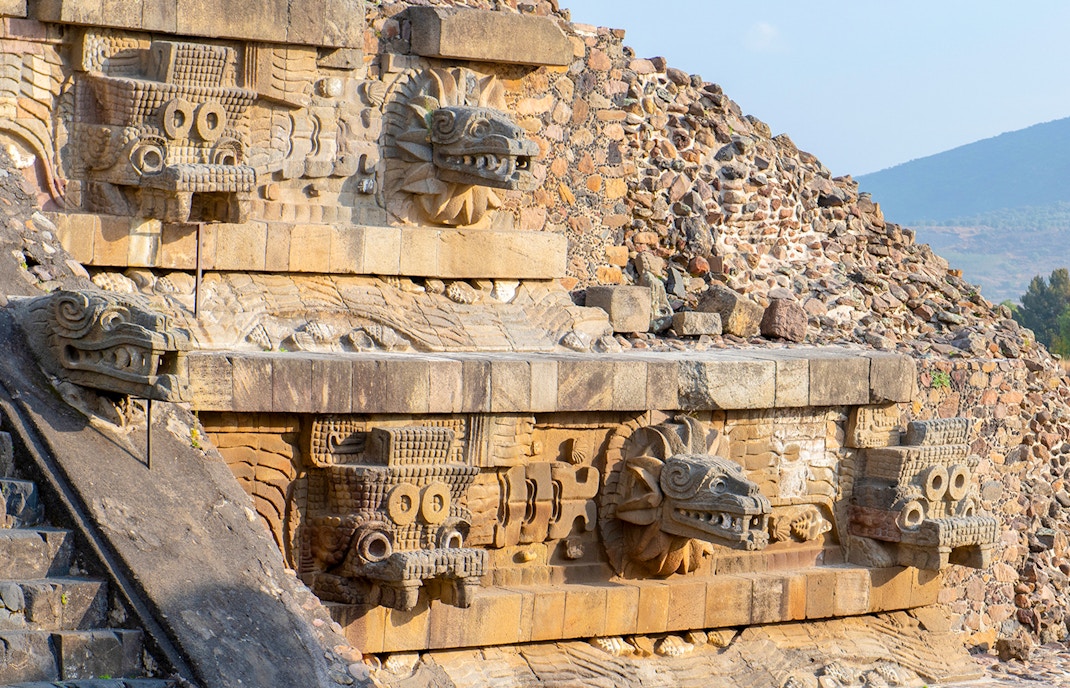 Temple of Quetzalcoatl with intricate carved stone serpent heads in Teotihuacan, Mexico.