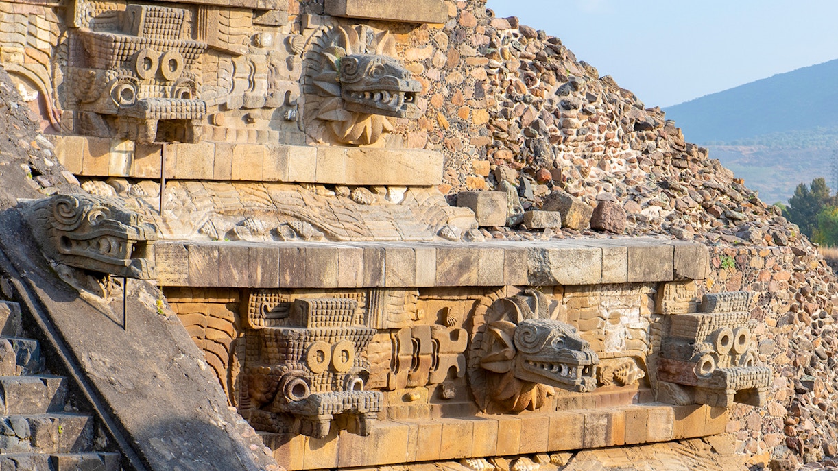 Temple of Quetzalcoatl with intricate carved stone serpent heads in Teotihuacan, Mexico.