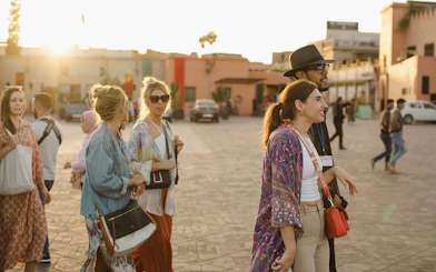 Tourists exploring the vibrant streets near Ben Youssef Medersa, Marrakech.