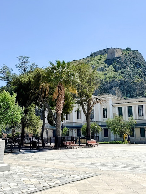Statue of Ioannis Kapodistrias in Kapodistrias Square, Nafplio, Greece, with Palamidi Fortress in background.