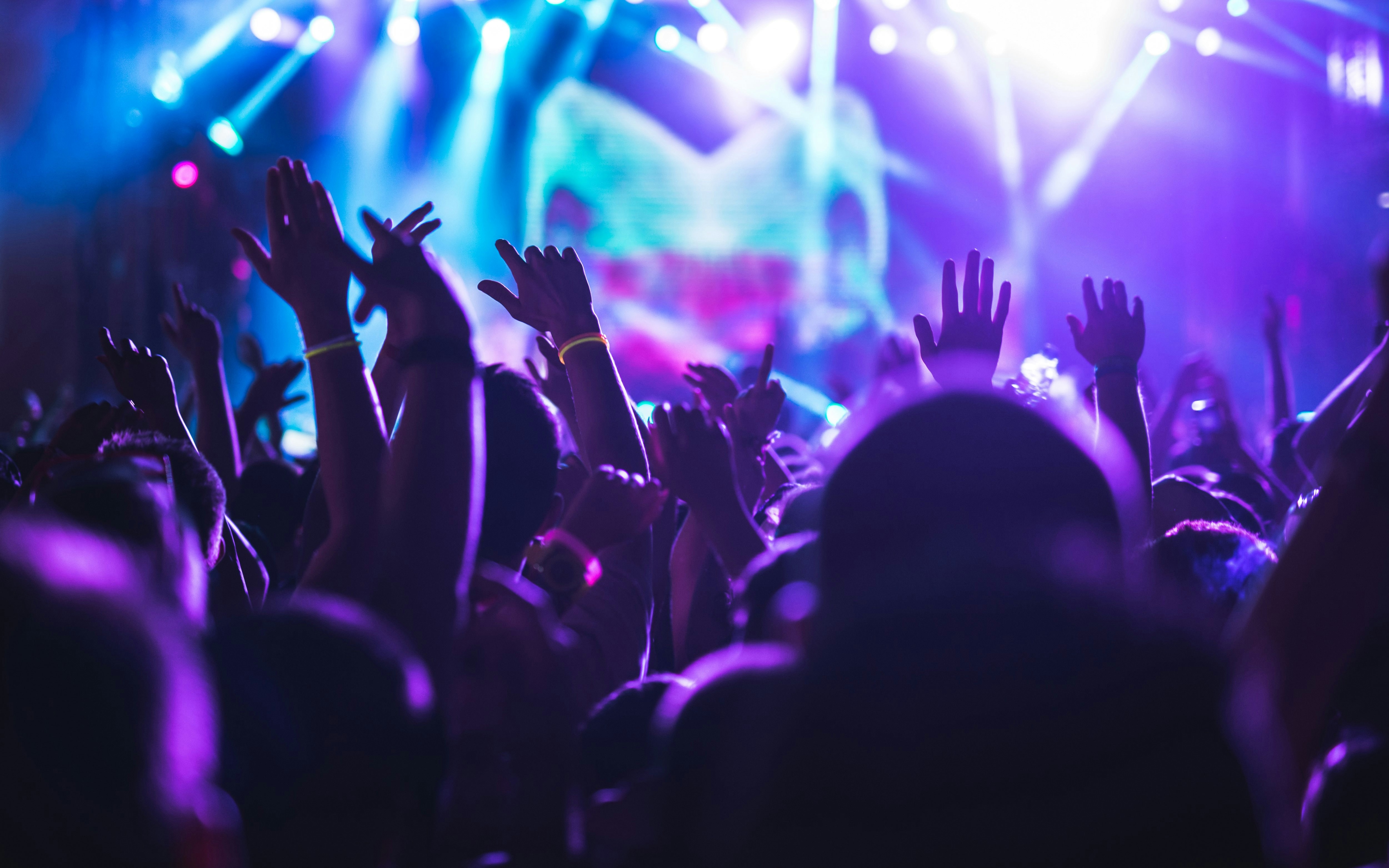 Crowd dancing under colorful lights at a disco event.