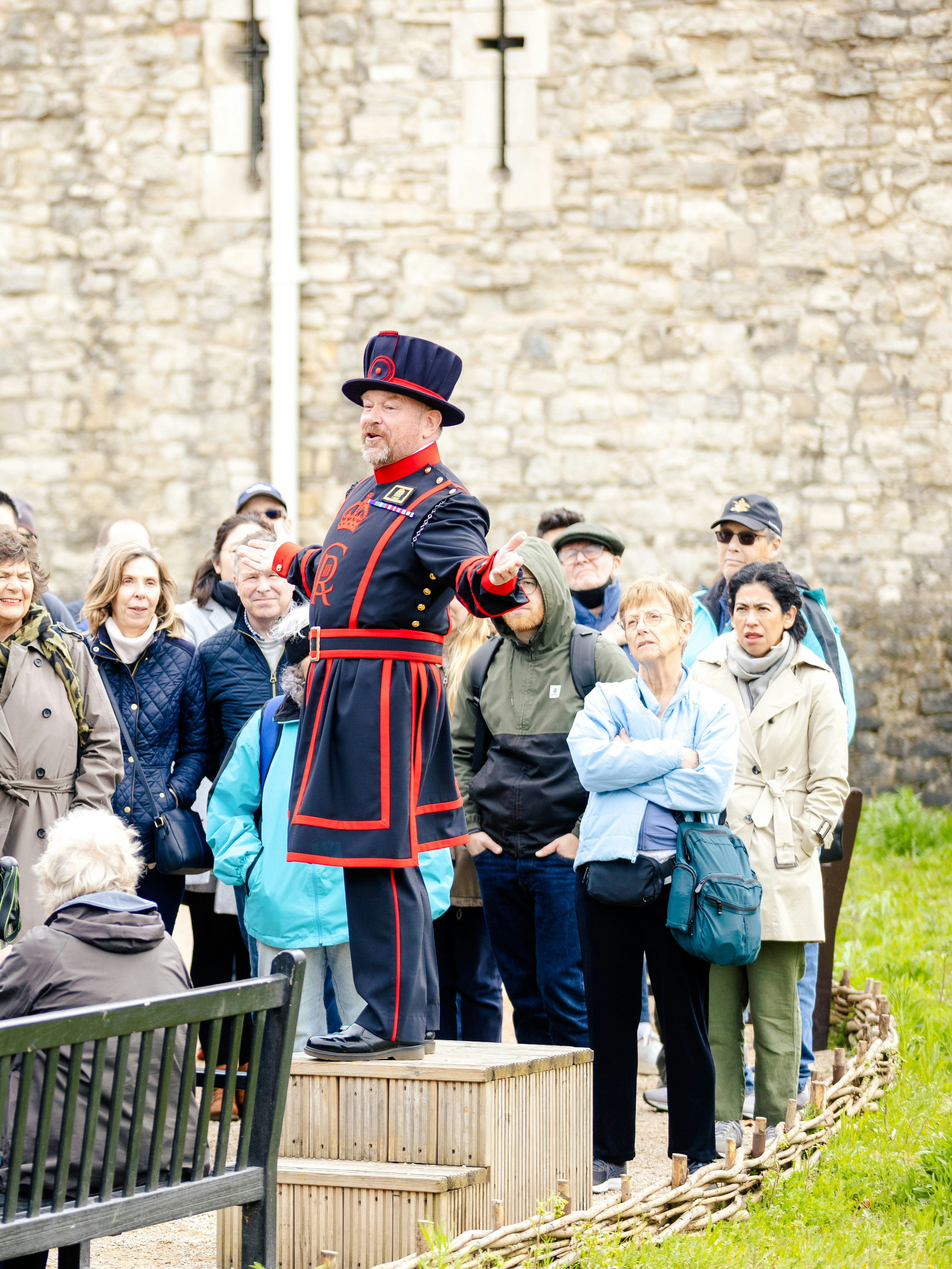 Guide in traditional attire leading a group tour at the Tower of London.