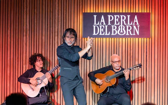 Flamenco performance at La Perla del Born in Barcelona with two guitarists and a dancer.
