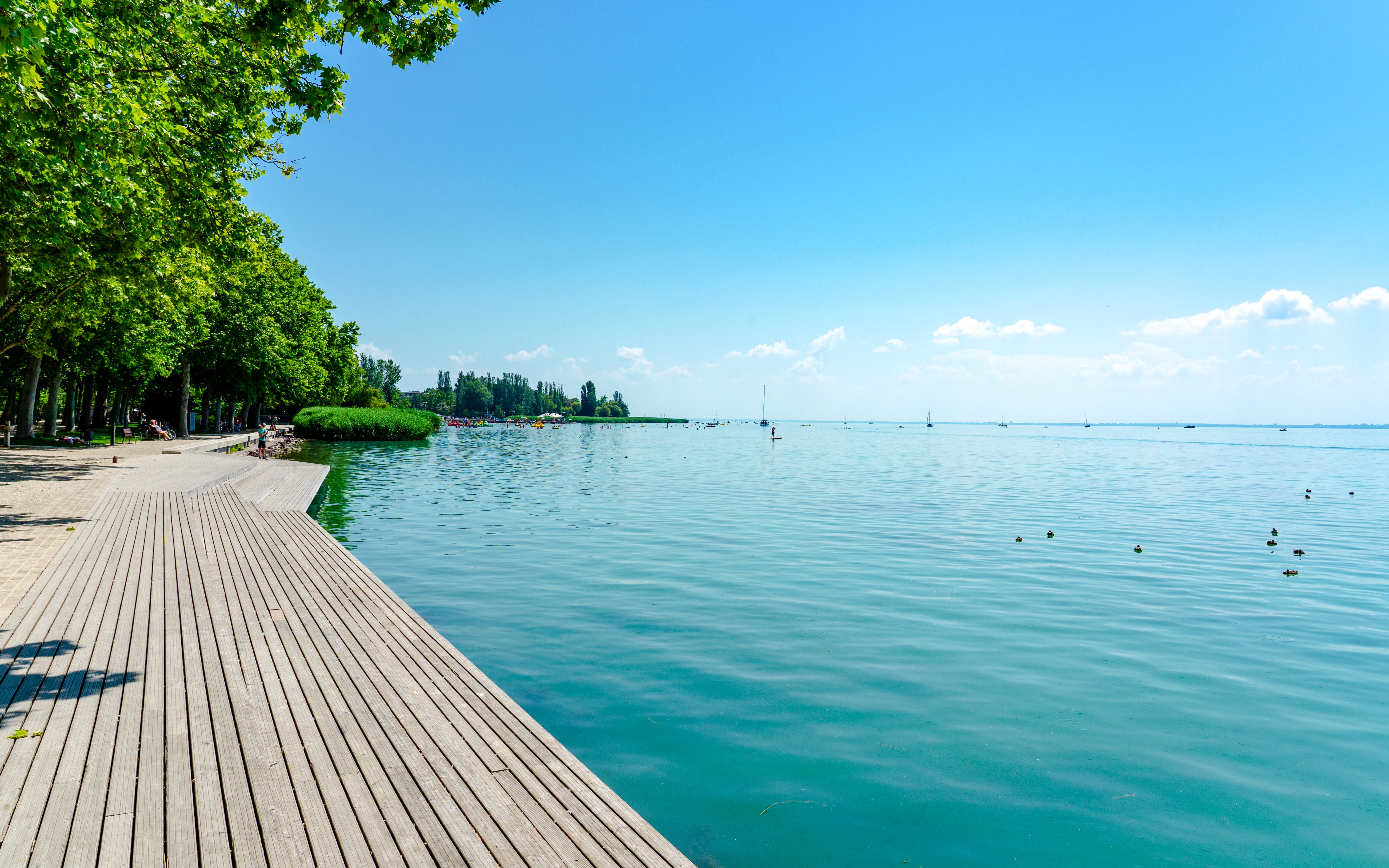Promenade in Balatonfüred along Lake Balaton with wooden lakeside walkway.