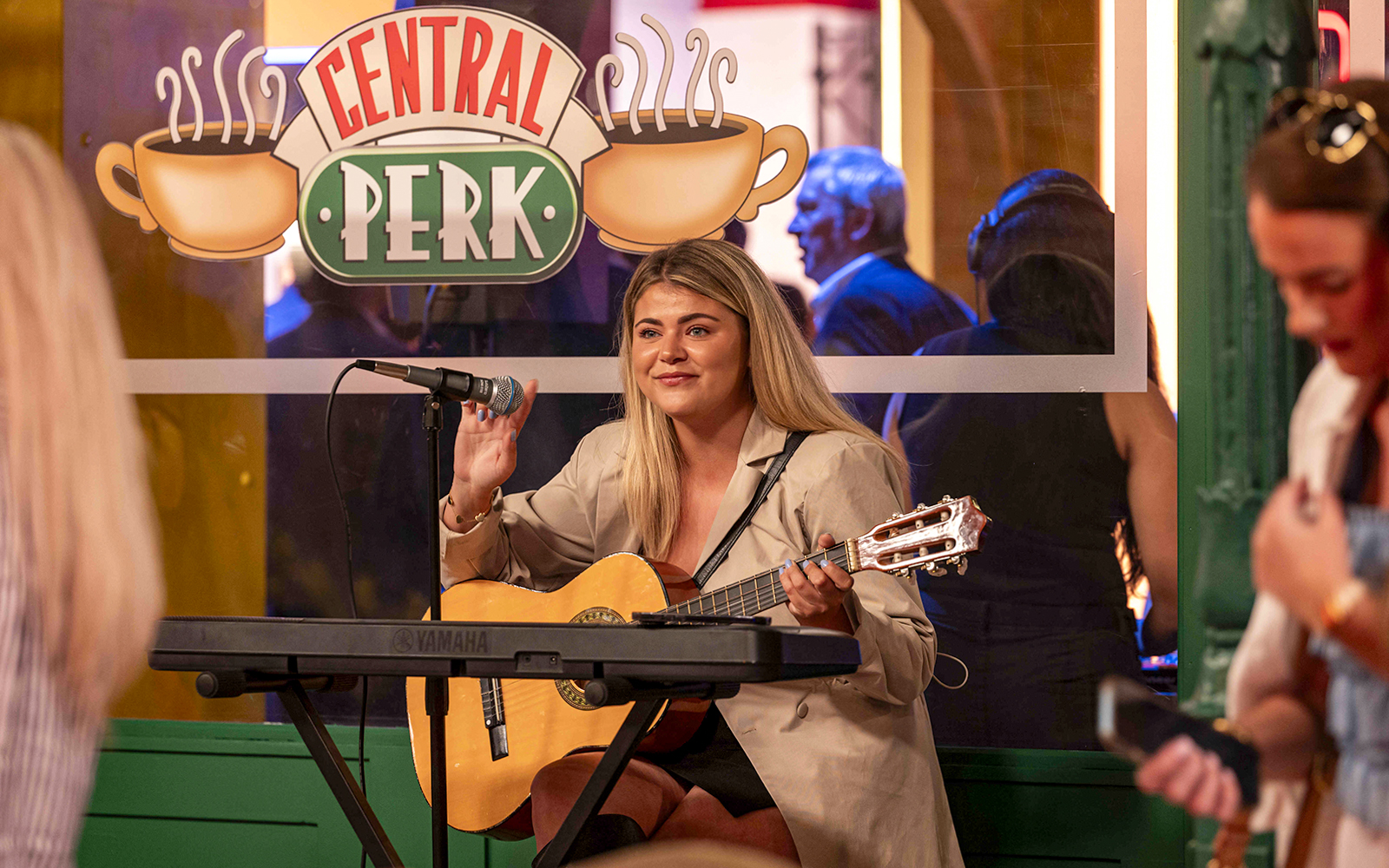 Musician playing guitar at Central Perk set during The FRIENDS™ Experience.